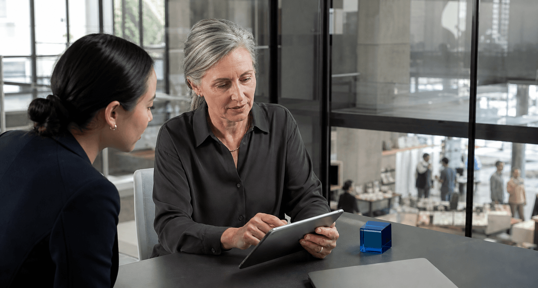 An experienced customer-care specialist reviewing context with a colleague before taking ownership